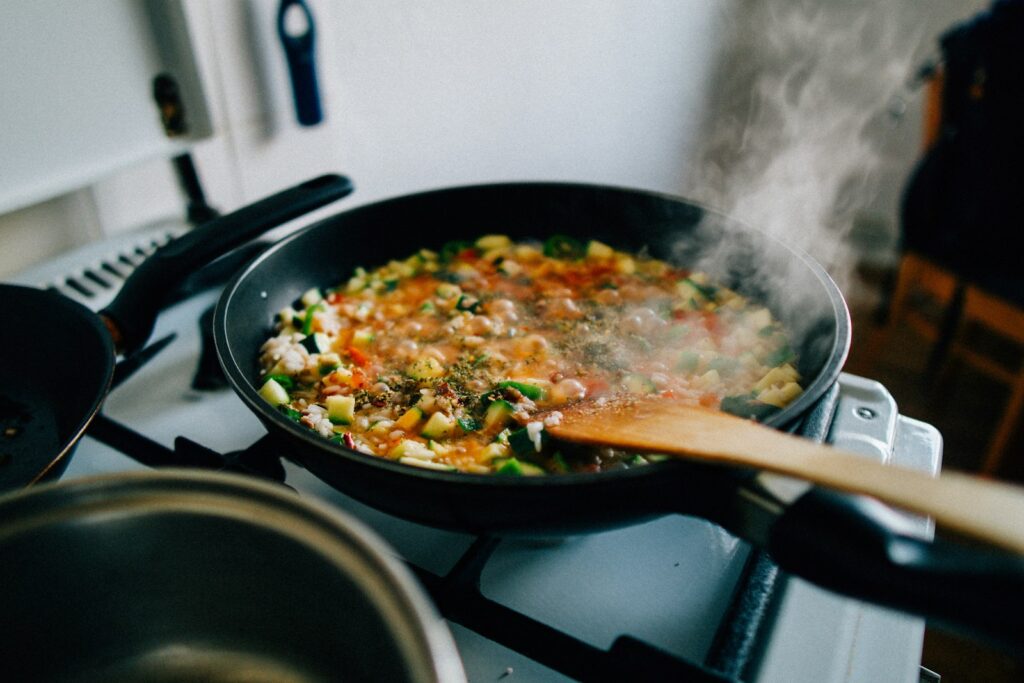 Pan of vegetables and rice cooking on a stove