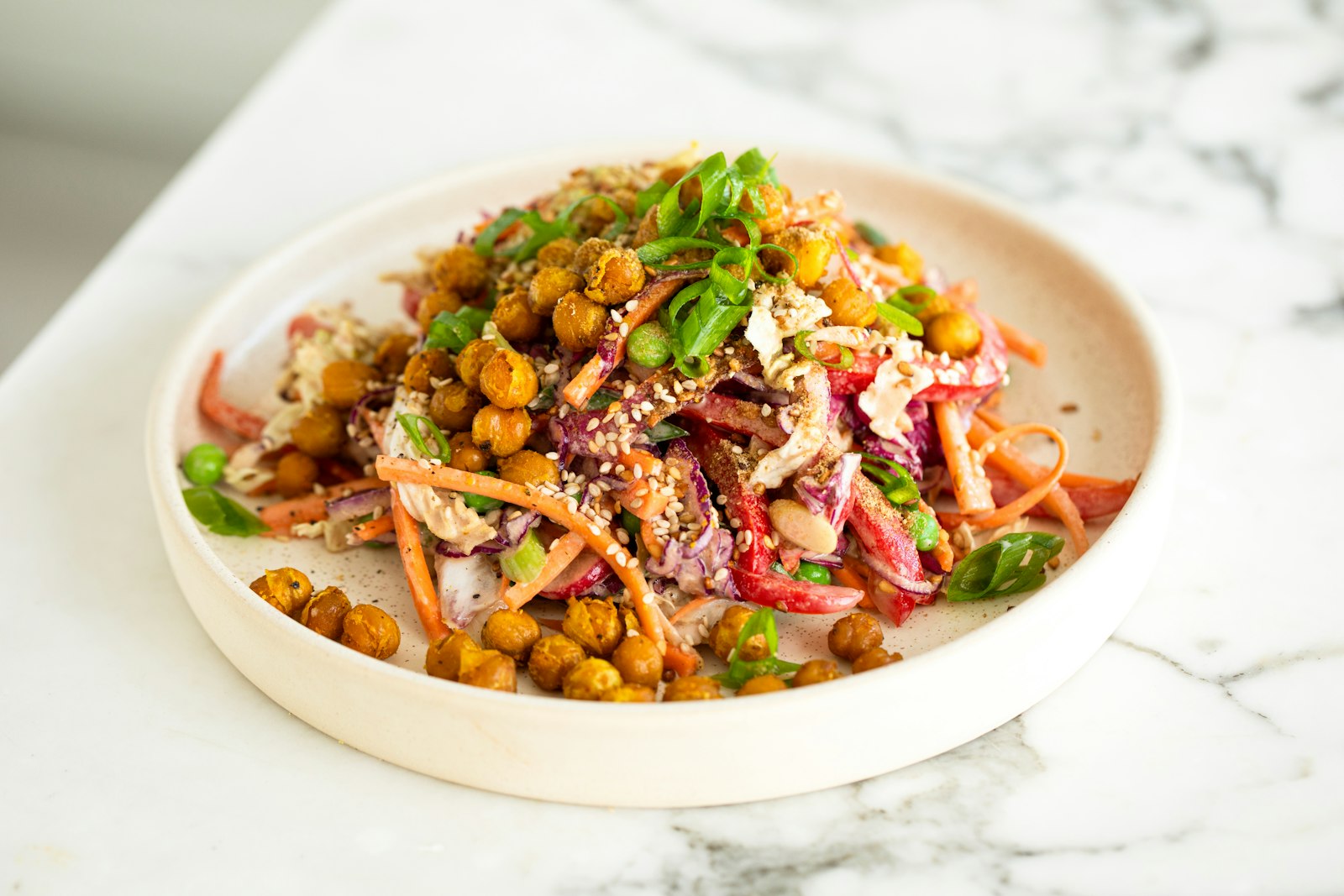 Cuenco blanco con ensalada de garbanzos y verduras