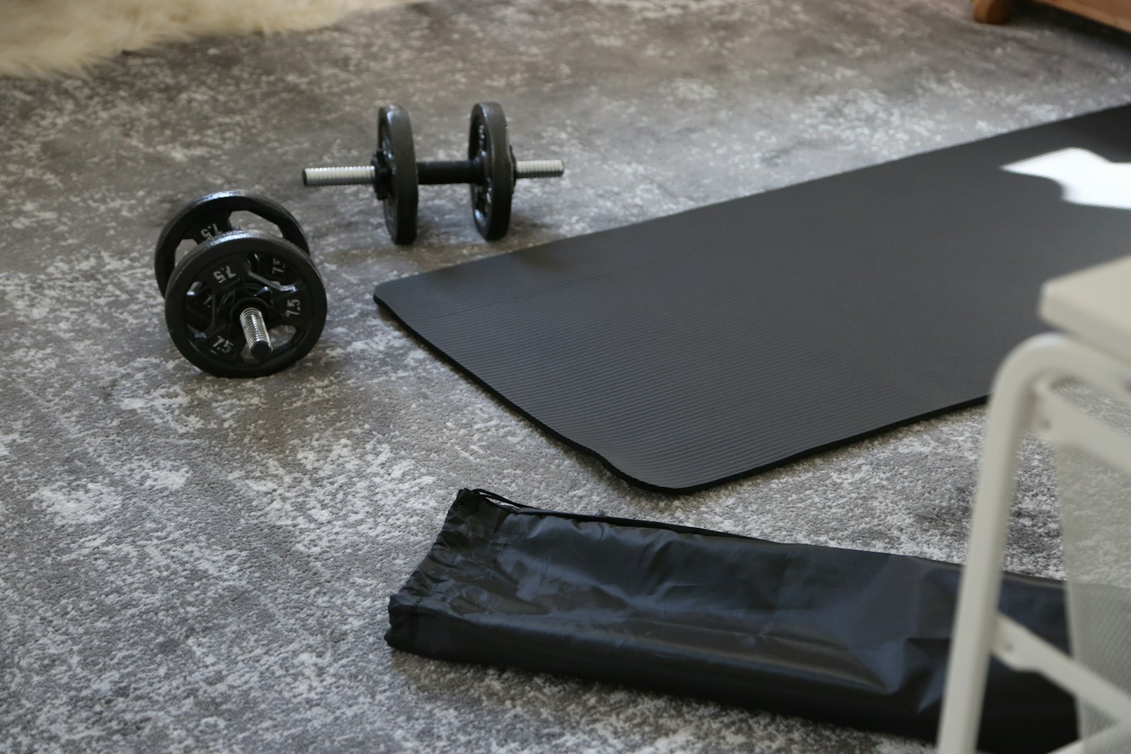 Dumbbells and an exercise mat on the floor at home